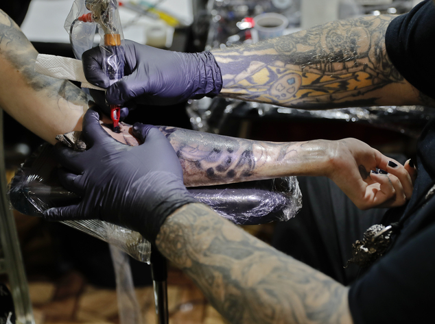 In this picture taken on Sunday, Oct. 16, 2016, Paul Booth of the U.S., one of the world's most famous tattoo artists, works during the International Tattoo Convention Bucharest 2016 in Bucharest, Romania. (AP Photo/Vadim Ghirda)