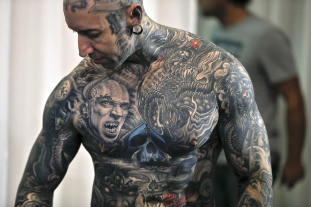 In this picture taken on Sunday, Oct. 16, 2016, Yall Quinones, from Puerto Rico, shows off his tattoos during the International Tattoo Convention Bucharest 2016 in Bucharest, Romania. More than 100 tattoo and piercing artists brought their skills and art to a three-day convention in the Romanian capital.(AP Photo/Vadim Ghirda)