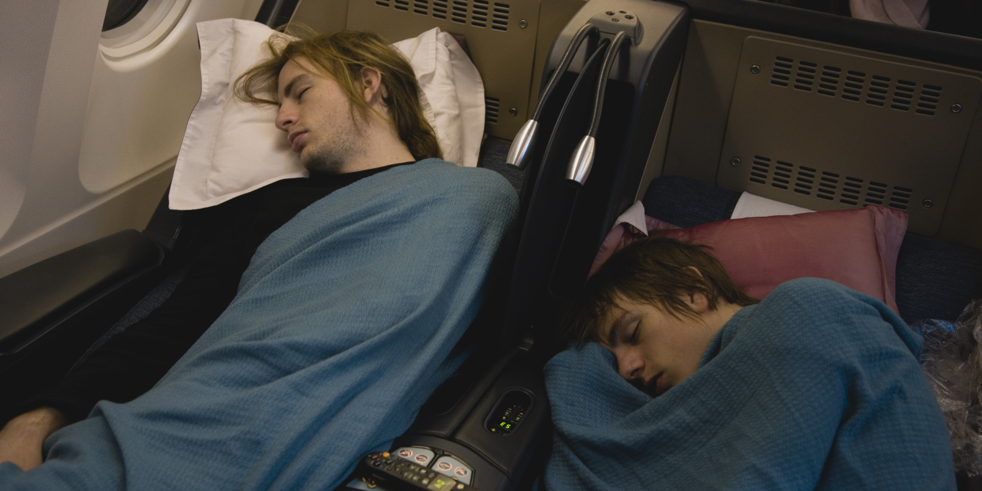 Two young men sleeping in airplane